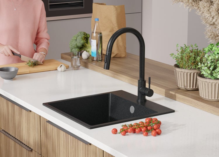 Schwarzes Küchenspülbecken mit Armatur in einer hellen Küche