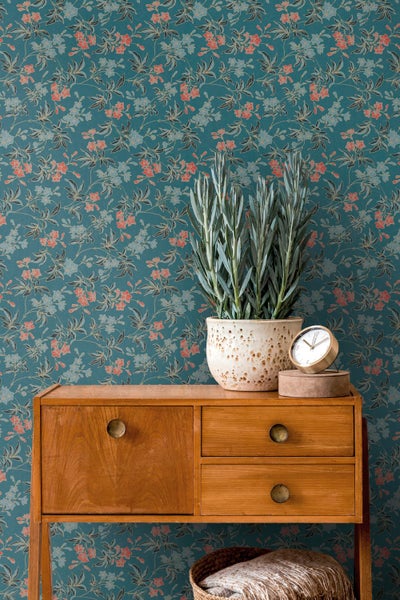 Nahaufnahme eines Raumes mit einer blauen Blumentapete, einem Kalender, einem Notizbuch und Stiften