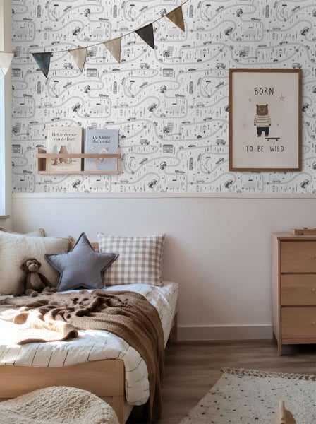 Kinderzimmer mit Tapete mit Straßenmuster, Holzmöbeln und dekorativem Wandbild mit Bärenmotiv in einer gemütlichen und hellen Wohnumgebung.