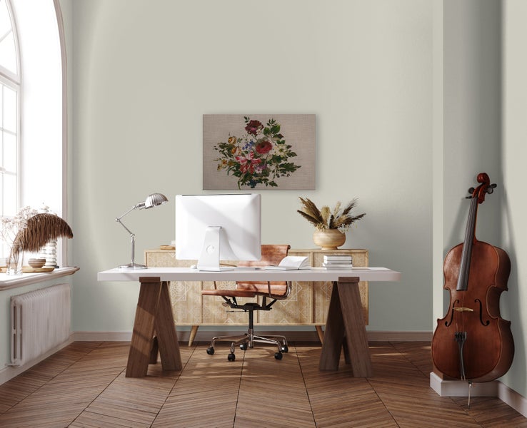 Helles Büro mit Schreibtisch, Stuhl, Computer und Kontrabass vor einer sanft gestrichenen Wand in einem Raum mit Fischgrätparkettboden.