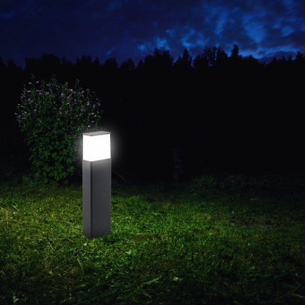 Garten mit beleuchteter Wegeleuchte bei Nacht