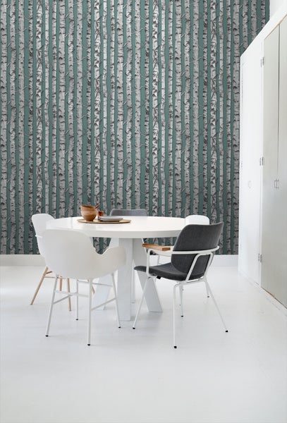 Esszimmer mit Tapete mit Birkenmuster, weißem Tisch und Stühlen.