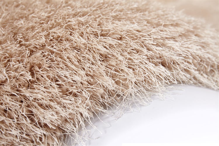 Beiger Hochflor-Teppich mit langen, weichen Fasern in Shaggy-Optik.