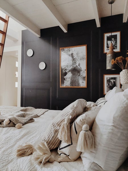 Schlafzimmer mit Bett, Kissen, Decke und Wanddekorationen für eine gemütliche Atmosphäre