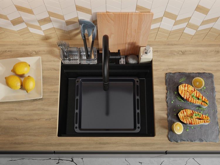 Küchenspüle mit Abtropfschale, Armatur und Küchenutensilien auf einer Arbeitsplatte