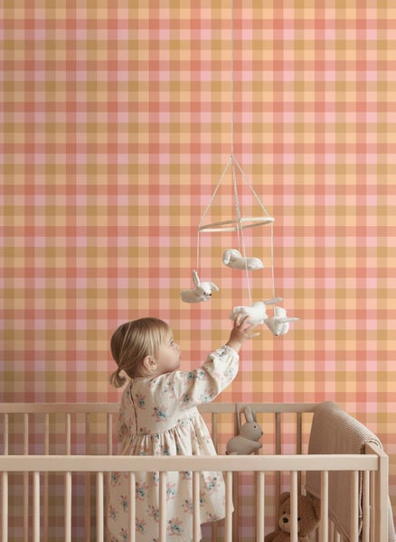 Vliestapete mit Karomuster im Kinderzimmer mit Gitterbett und Mobile.