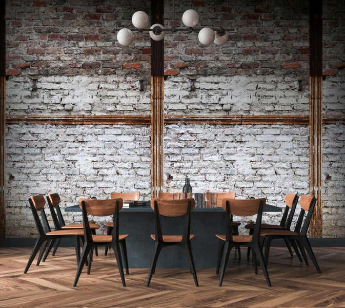 Esszimmer mit Esstisch, Stühlen und Ziegelwand