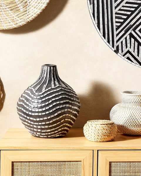 Dekorative Vasen und Körbe auf einem Holzschrank