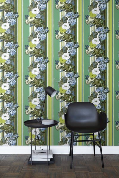 Dekoratives Zimmer mit gestreifter Blumentapete, schwarzem Stuhl und Beistelltisch mit Lampe.