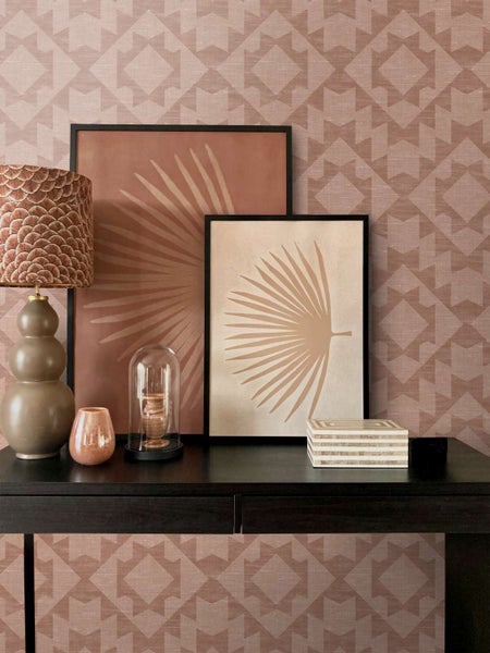Vlies-Tapete mit geometrischem Muster auf einem Sideboard dekoriert mit Tischleuchte und Bildern in einer modernen Einrichtung.