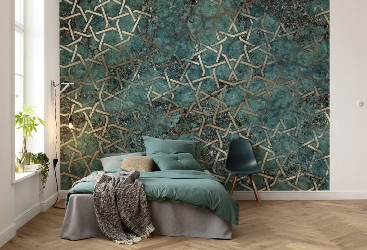 Schlafzimmer mit Bett vor einer Wand mit geometrischem Muster