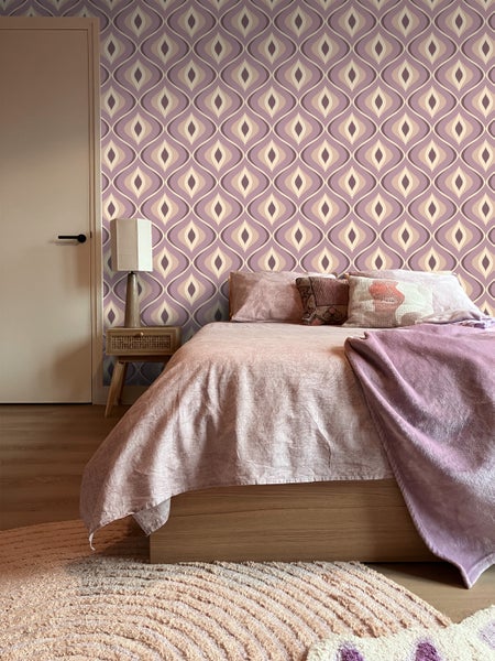 Schlafzimmer mit Bett und gemusterter Tapete im Retro-Stil