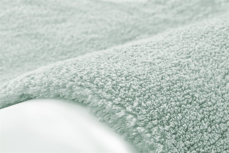 Detailansicht eines Hochflor-Badeteppichs mit weicher Struktur.