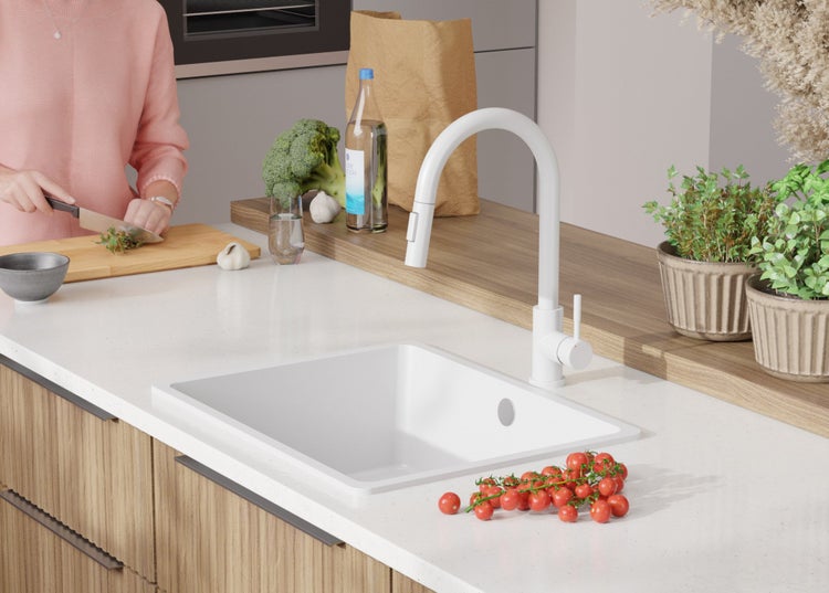 Küchenspüle mit Armatur und frischen Zutaten auf der Arbeitsfläche