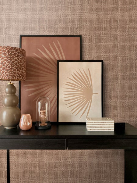 Dekoratives Interieur mit Tisch, Lampe und Wandbildern mit Pflanzenmotiven