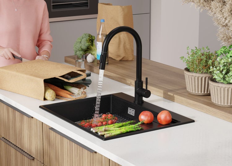 Spüle mit Armatur, Gemüse und Person in der Küche