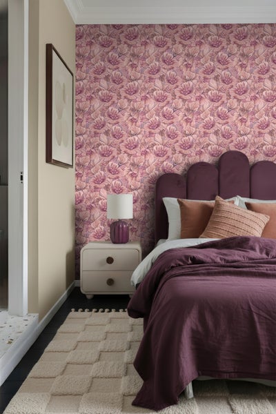 Schlafzimmer mit floraler Tapete, Bett, Nachttisch und Teppich