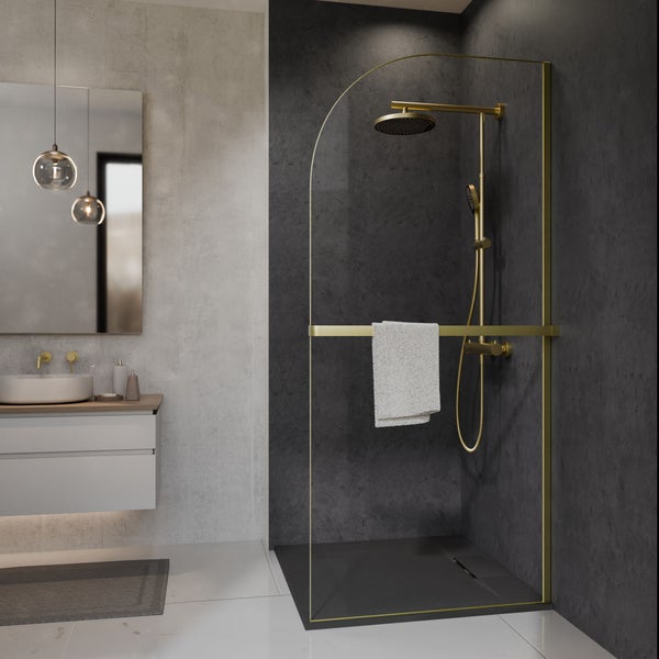 Begehbare Dusche mit goldfarbenem Rundbogen-Profil und Armaturen, Waschtisch und Spiegel in einem modernen Badezimmer mit grauen Steinwänden.