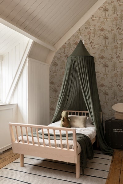 Kinderzimmer mit Bett, Baldachin und Dinosaurier-Tapete