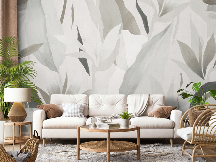 Wohnzimmer mit Sofa, Couchtisch und blättriger Fototapete für eine helle, organisierte Atmosphäre.