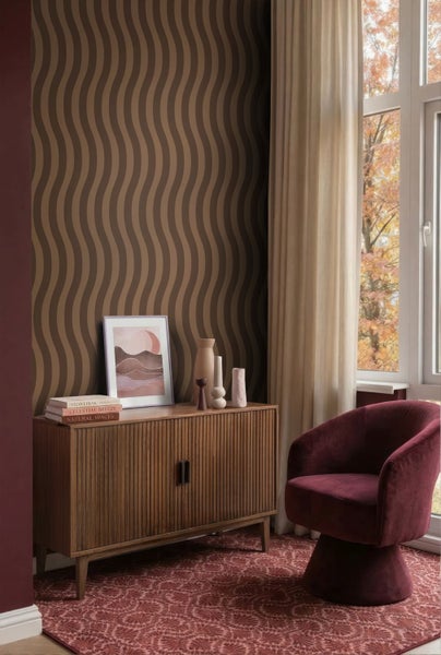 Braune Vliestapete mit Wellenmuster in einem modern eingerichteten Wohnzimmer mit Holzkommode, Samtsessel und Teppich.