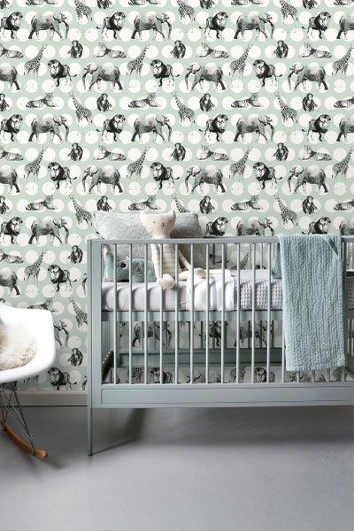 Babyzimmer mit einer Tapete mit Tiermotiven und einem Gitterbett