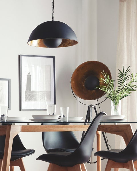 Esstisch mit Stühlen, Geschirr, Dekoration und Beleuchtung in einem hellen Raum