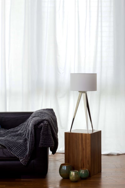 Zimmer mit Sofa, Wolldecke, Stehleuchte und Dekoration