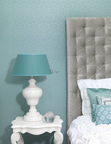 Dekorative Schlafzimmerszene mit Nachttisch, Lampe und Bett mit gestepptem Kopfteil