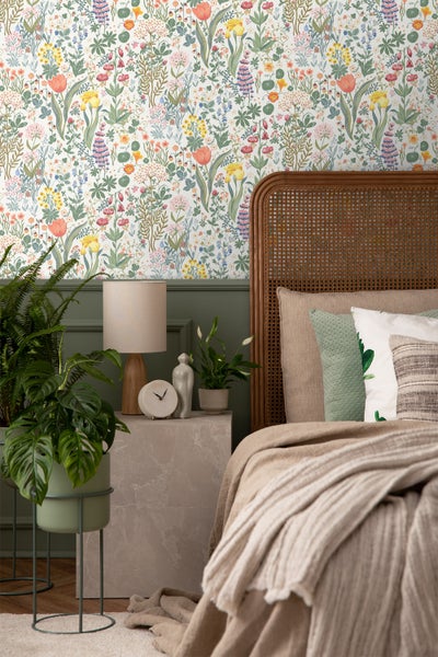 Ein helles Schlafzimmer mit einer Wand bedeckt mit Blumentapete
