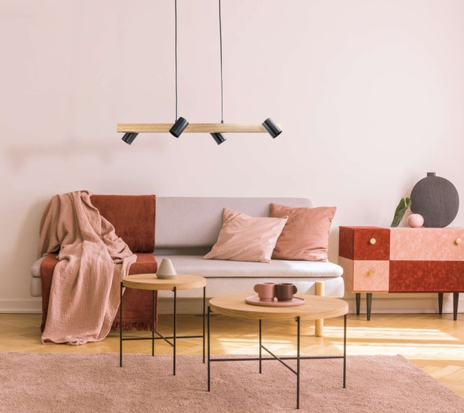 Wohnzimmer mit Sofa, Couchtischen und Hängelampe