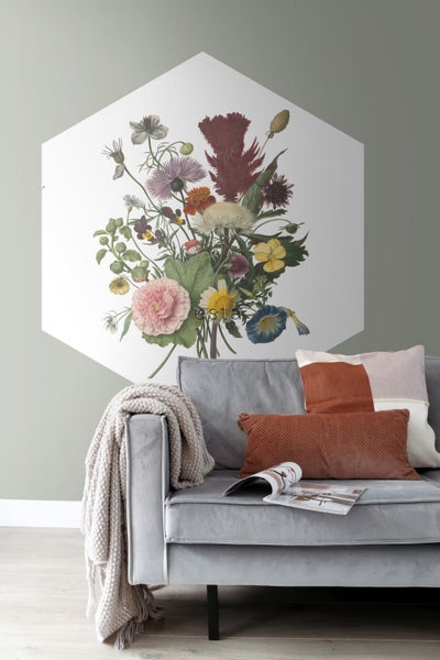 Wandpaneel mit Blumenmotiv über einem grauen Sofa