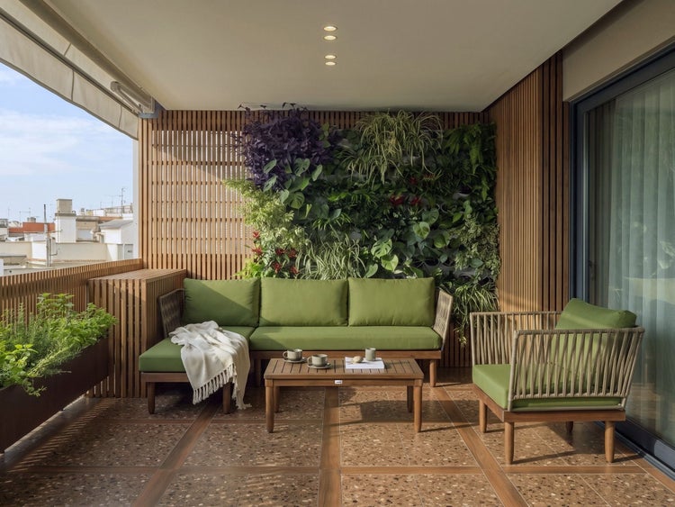 Moderner Balkon mit Holzmöbeln, grünen Polstern, vertikalem Garten, Holzverkleidung und Terrazzoboden.