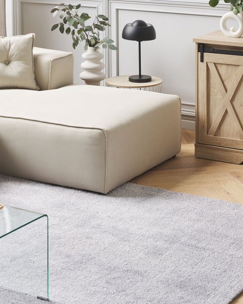 Wohnzimmer mit Sofa, Teppich und Beistelltisch