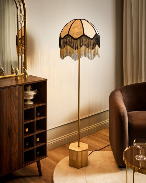 Dekorative Stehlampe mit gemustertem Schirm und Fransen im Wohnzimmer