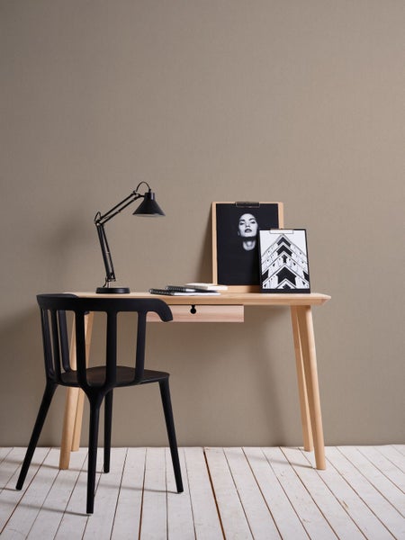 Nahaufnahme einer Wand mit Textiltapete, dekoriert mit Regalen und verschiedenen Dekorationsartikeln