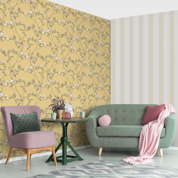 Wohnzimmer mit blumiger Tapete, Sessel, Sofa und Tisch