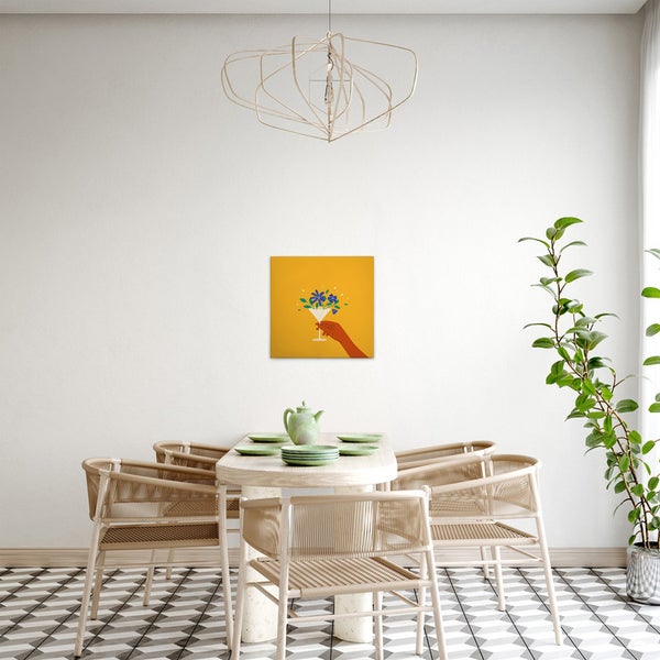 Esszimmer mit Holztisch, Stühlen, Zimmerpflanze, Lampe und einem gelben Bild mit Hand und Cocktailglas an der Wand.