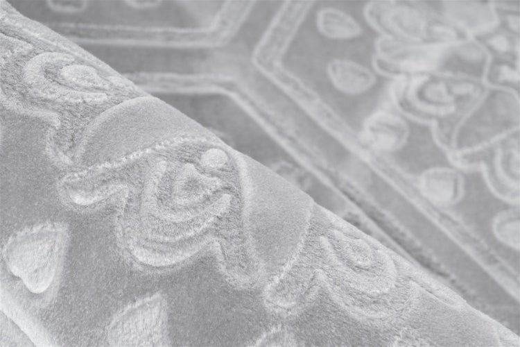 Nahaufnahme eines weichen Teppichs mit Hoch-Tief-Struktur und Ornamentmuster.