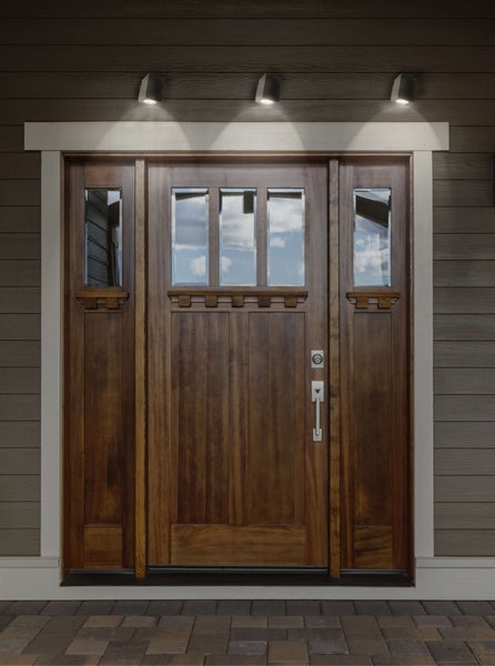 Hauseingangstür aus Holz mit Glaseinsätzen und Außenbeleuchtung
