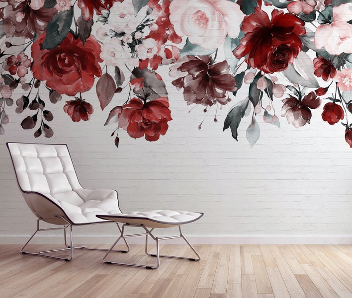Fototapete mit großen Aquarell-Rosen auf weißem Ziegelhintergrund, abgebildet in einem modernen Wohnzimmer mit weißem Sessel.
