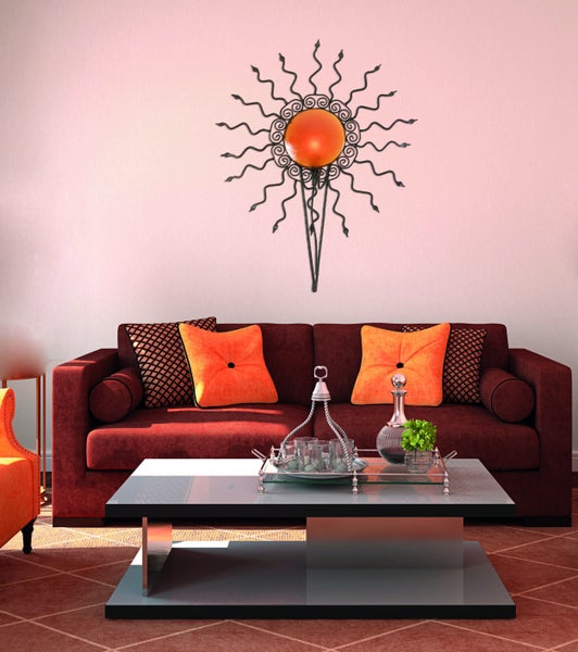 Wohnzimmer mit Sofa, Couchtisch und dekorativer Wandkunst in Sonnenform.