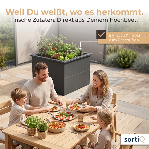 Familie beim Essen auf der Terrasse neben einem anthrazitfarbenen Hochbeet mit Gemüse und Kräutern inklusive Pflanzsticks. sortiQ Logo.