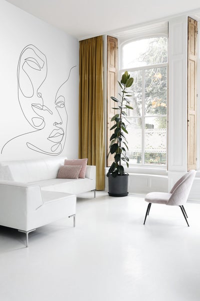 Helles Wohnzimmer mit Sofa, Stuhl, Zimmerpflanze, Fenster und Wandbild