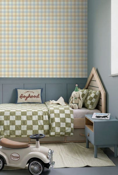 Kinderzimmer mit karierter Tapete, Hausbett aus Holz, grün-weißem Bettzeug, blauem Nachtschrank und einem Spielzeugauto.