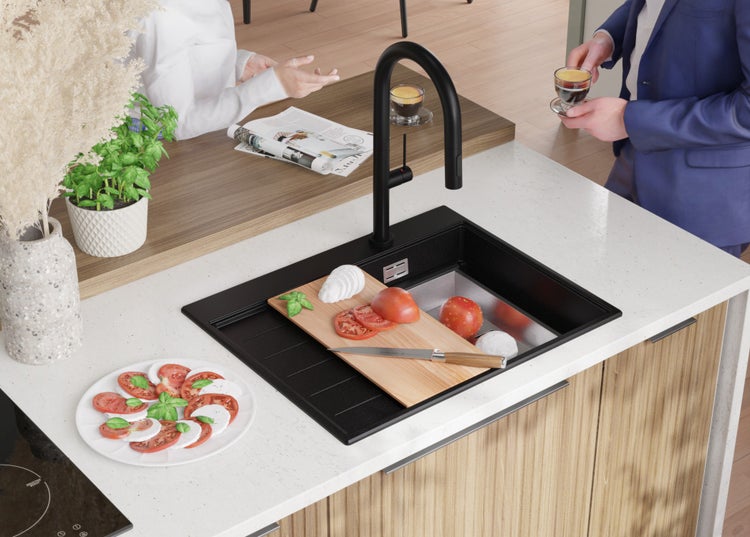 Spüle mit Armatur, Schneidebrett mit Tomaten und Mozzarella auf einer Küchentheke