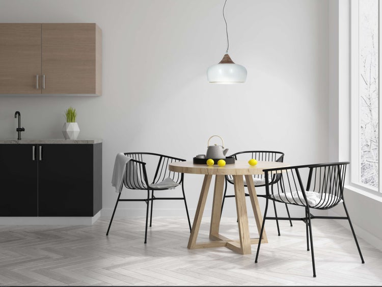 Heller Essbereich mit Holztisch und schwarzen Stühlen, Teekanne und Zitronen