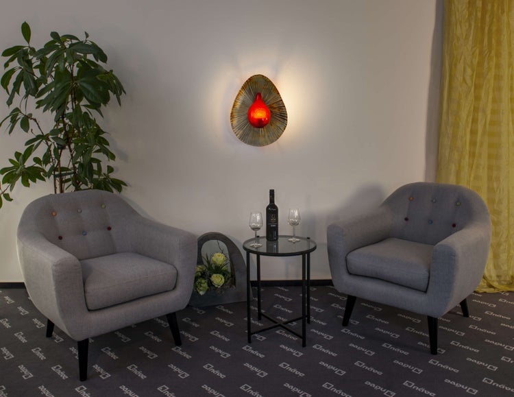 Dekorative Szene mit zwei Sesseln, Stehleuchte und Beistelltisch mit Weinarrangement.