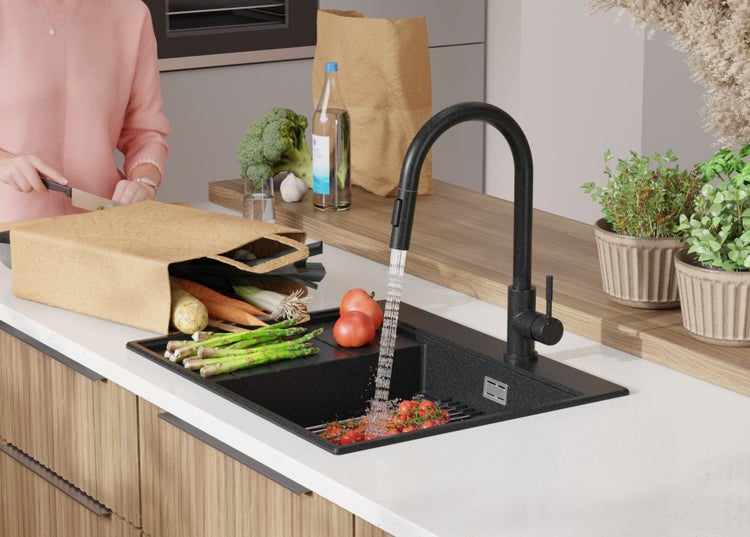 Spüle mit Armatur, Gemüse und Person in einer modernen Küche