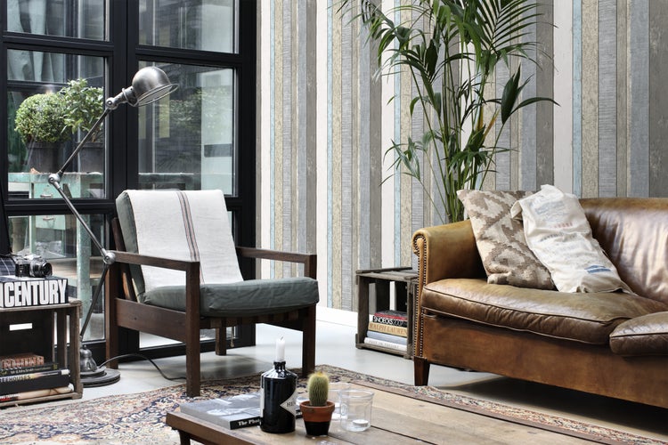 Wohnzimmer mit Ledersofa, Sessel, Stehlampe und Teppich